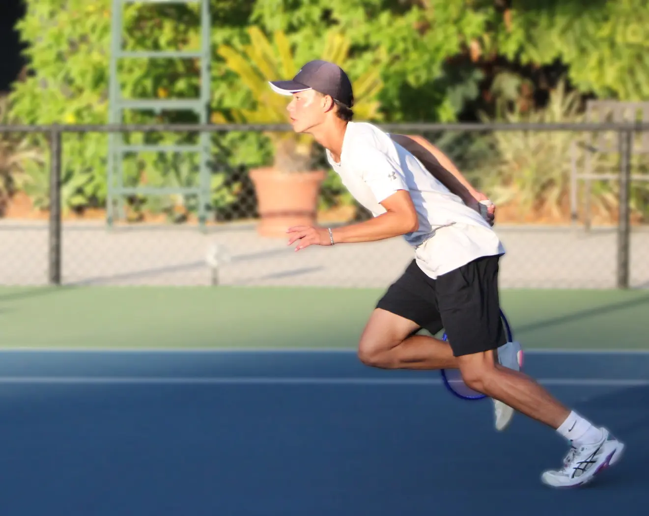 Junior boy charging forward during tennis training