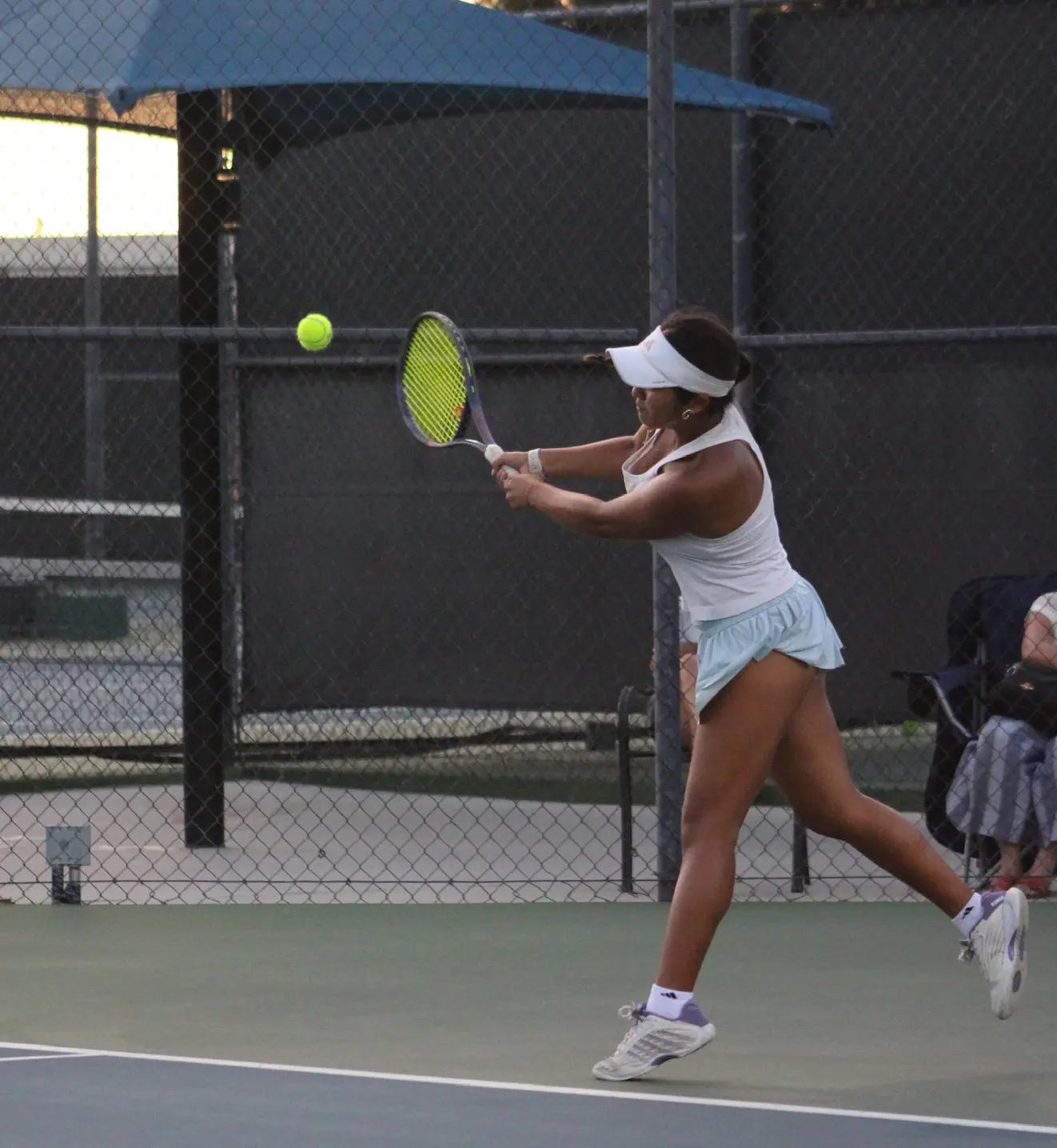 Junior tennis player hitting a backhand