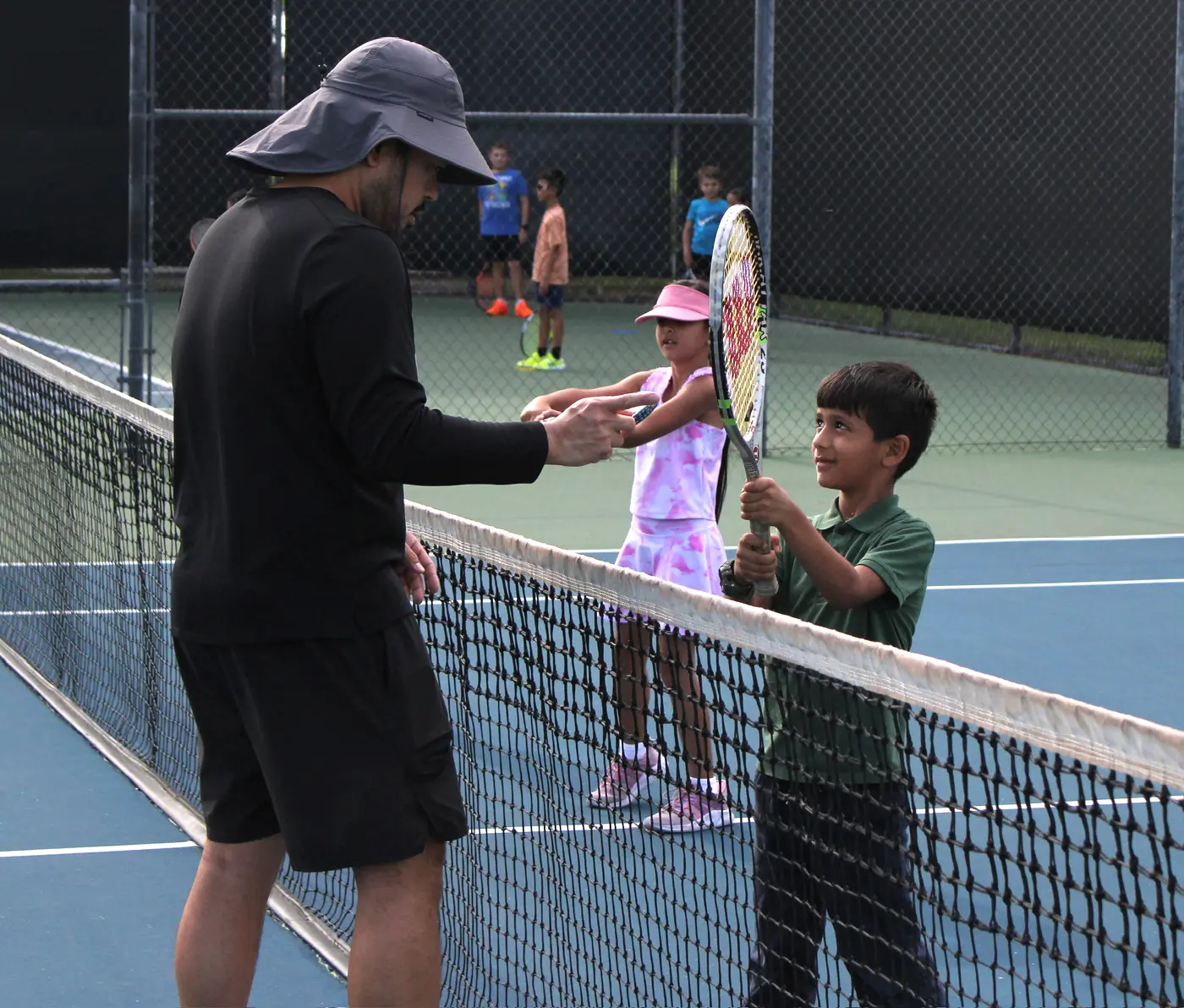 Junior tennis coach working with young players