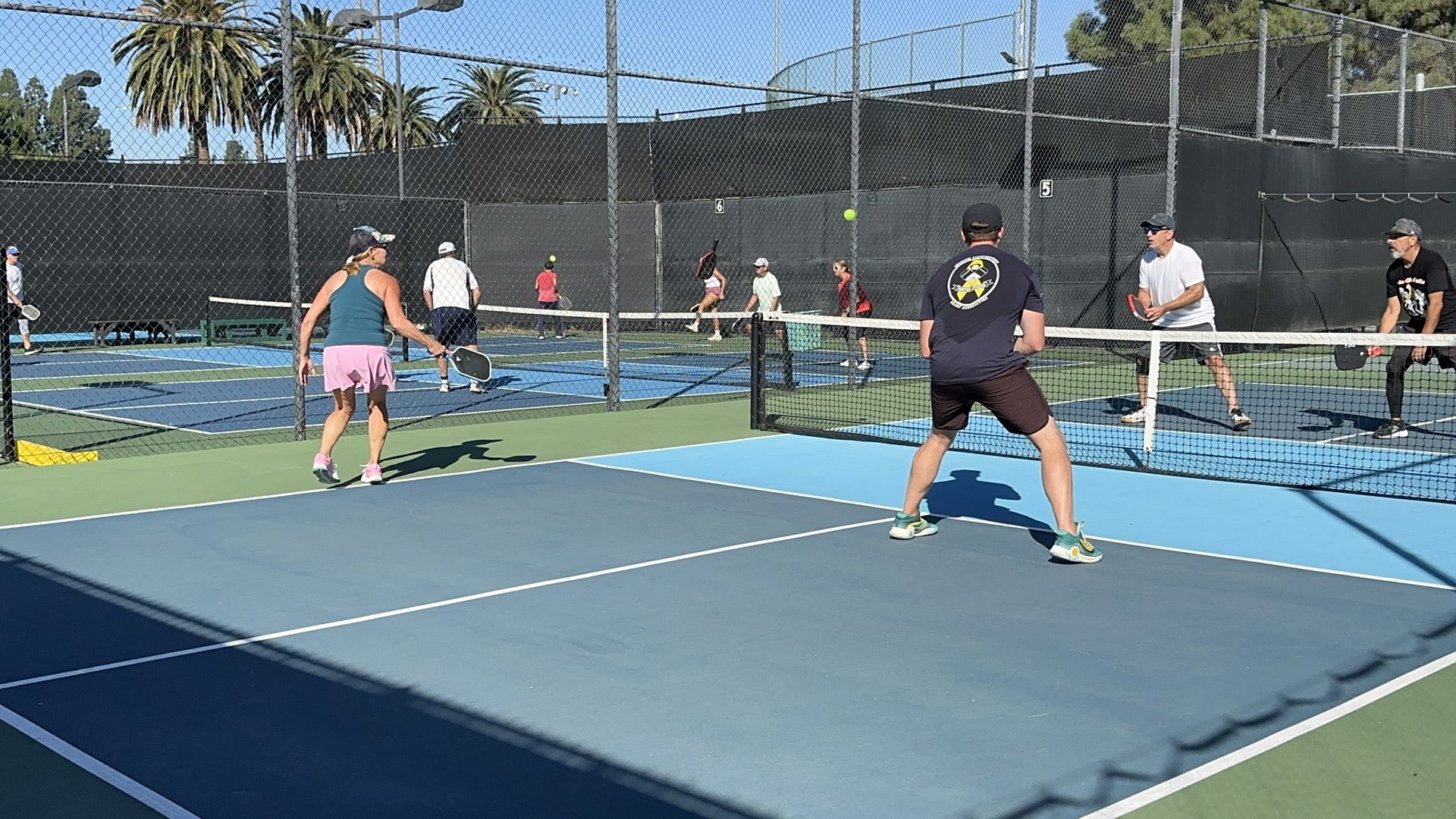People playing pickleball on outdoor courts.