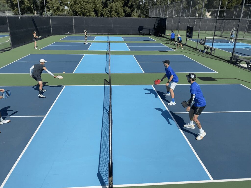 People playing pickleball on outdoor courts.